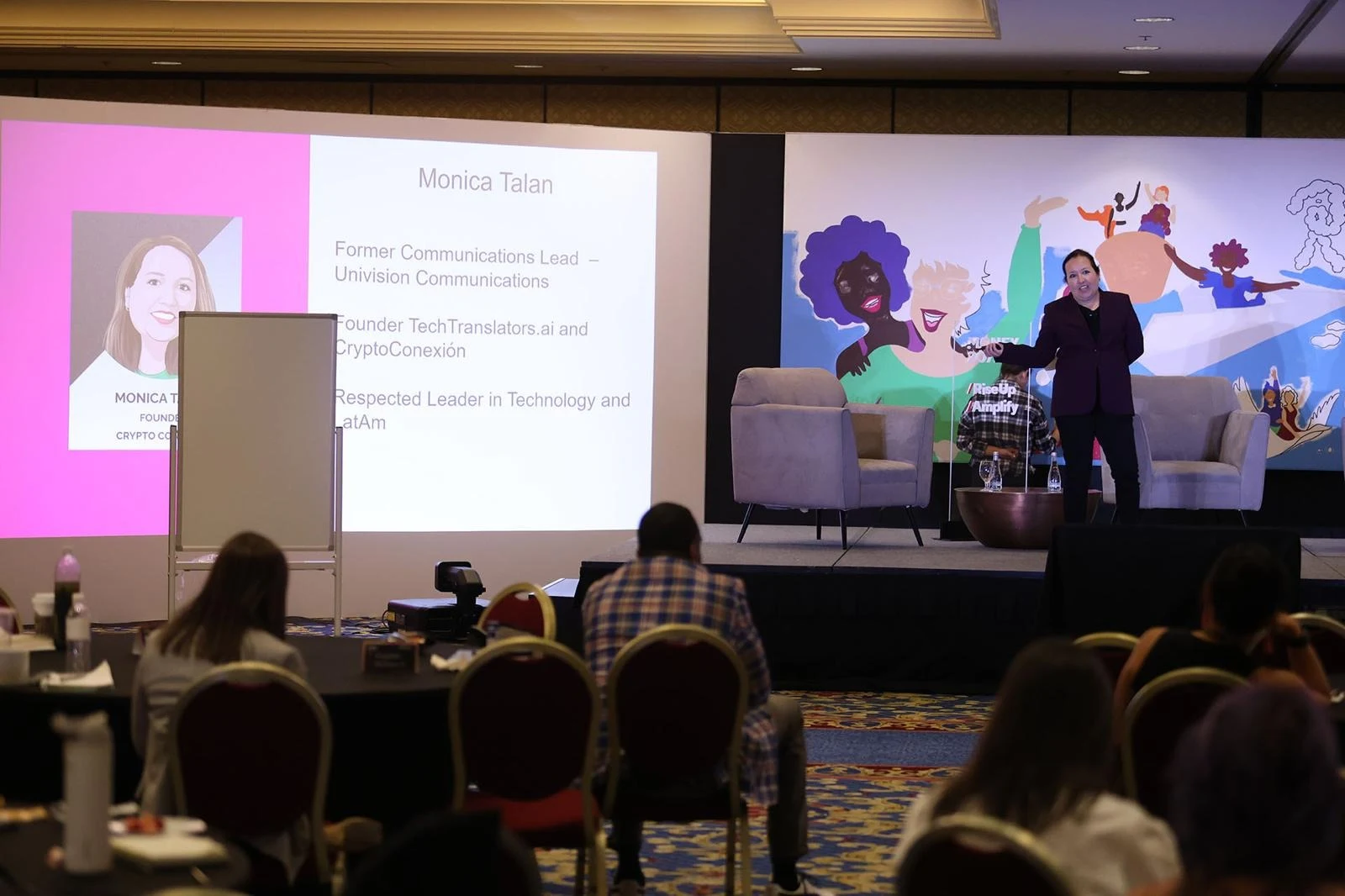Monica Talan presenting on stage during a technology event
